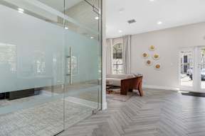 A modern living room with a glass door and a wooden chair.