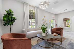A living room with a brown chair, a grey table, and a green plant.