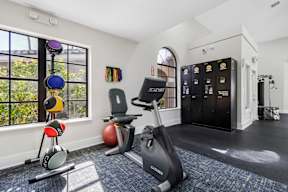 A gym with a variety of equipment including a treadmill, exercise balls, and a weight bench.
