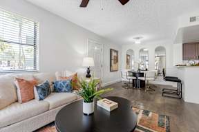 A living room with a white couch and a black coffee table.