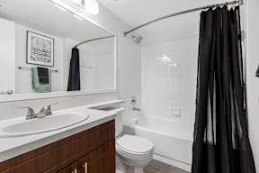 A bathroom with a white sink, toilet, and bathtub.
