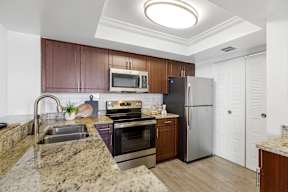A kitchen with brown cabinets and a granite countertop.