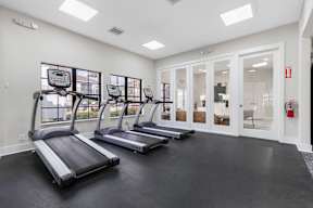 A gym with treadmills and a fire extinguisher.