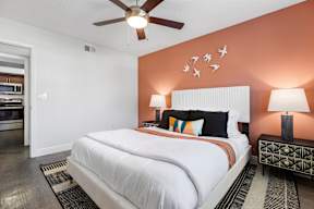 A bedroom with a large bed and a ceiling fan.