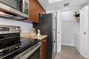 A kitchen with a black stove top oven and a black refrigerator.