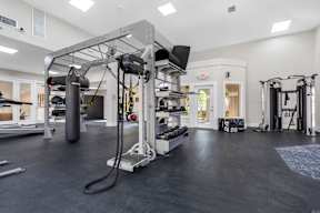A gym with a variety of equipment including a punching bag and weight machines.