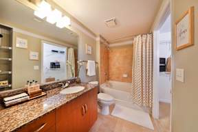 A bathroom with a sink, mirror, and shower.