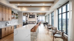 a large kitchen with a large island and chairs in front of large windows