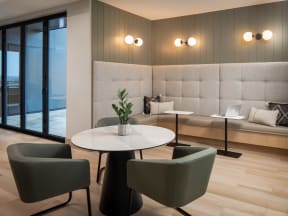 a room with a table with chairs and a laptop