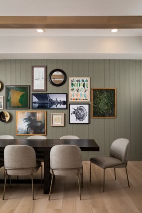 a dining room with a table and chairs and art on the wall