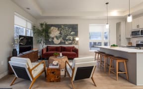 a living room with a couch and a kitchen with a table and chairs