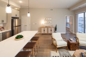 an open kitchen and living room with a large white counter top