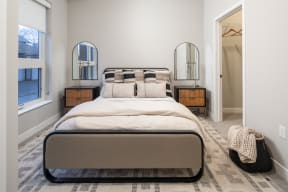 a bedroom with a large bed and two mirrors