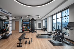 a gym with weights and exercise equipment and a large window