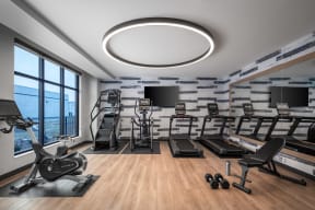 a gym with treadmills and other exercise equipment and a large window