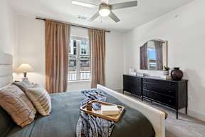a bedroom with a bed and a ceiling fan
