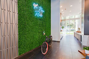 a bike parked in front of a green wall with a neon sign