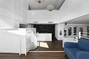 A white kitchen with a blue sofa.