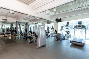 A gym with a variety of equipment including treadmills, weights, and exercise machines.