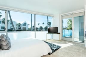 A bedroom with a large bed and a flat screen TV.