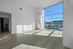 A room with a large window and wooden flooring.