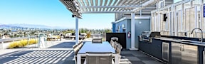A patio with a table and chairs overlooking a city.