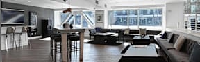 A modern living room with a bar area and a view of the city.
