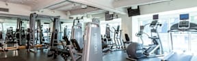 A gym with a variety of exercise equipment including treadmills, weights, and exercise machines.
