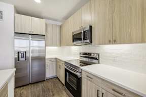 A kitchen with a stainless steel refrigerator, oven, and microwave.