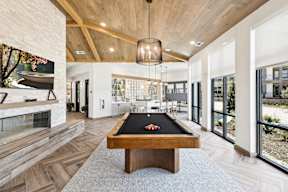 a pool table in the center of a house with a living room