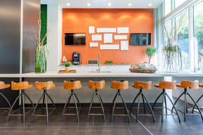 a kitchen with wooden bar stools in front of a large window
