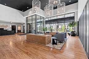 A modern interior lobby with a wooden floor and a glass wall.