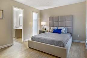 A bedroom with a large bed and a dresser.