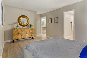 A bedroom with a bed, dresser, and mirror.