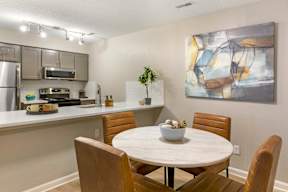 A modern kitchen with a dining table and chairs.