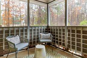 A patio with a chair and a bench with a table in front of it.