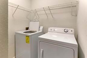A white washing machine and dryer in a small laundry room.