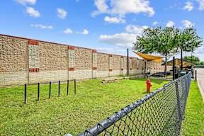 a brick wall with a chain link fence and a red fire hydrant