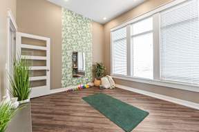 A room with a green rug on the floor and a white door on the left.