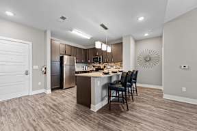 A modern kitchen with a wooden floor and a large island.