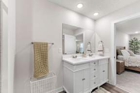 A white bathroom with a vanity and a mirror.