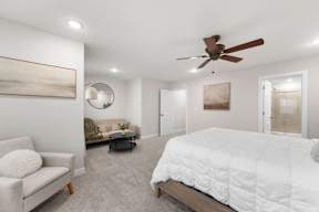 A bedroom with a large bed and a ceiling fan.