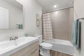 A white toilet sits next to a white sink in a bathroom.