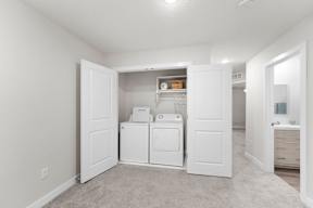 A white laundry room with a washer and dryer.