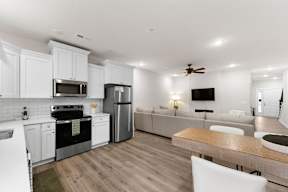 A modern kitchen with white cabinets and stainless steel appliances.