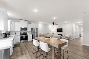 A modern kitchen with a dining table and chairs.