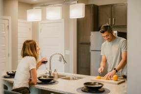 A man and a woman are preparing food in a kitchen.