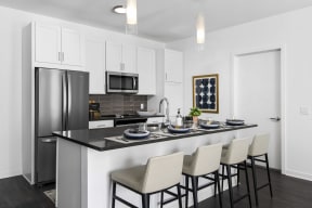 a kitchen with a counter top and a stainless steel refrigerator