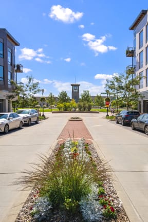 a city street with cars and a clock tower in the distance