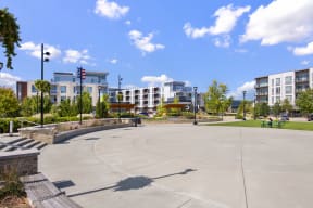 an empty park with buildings in the background